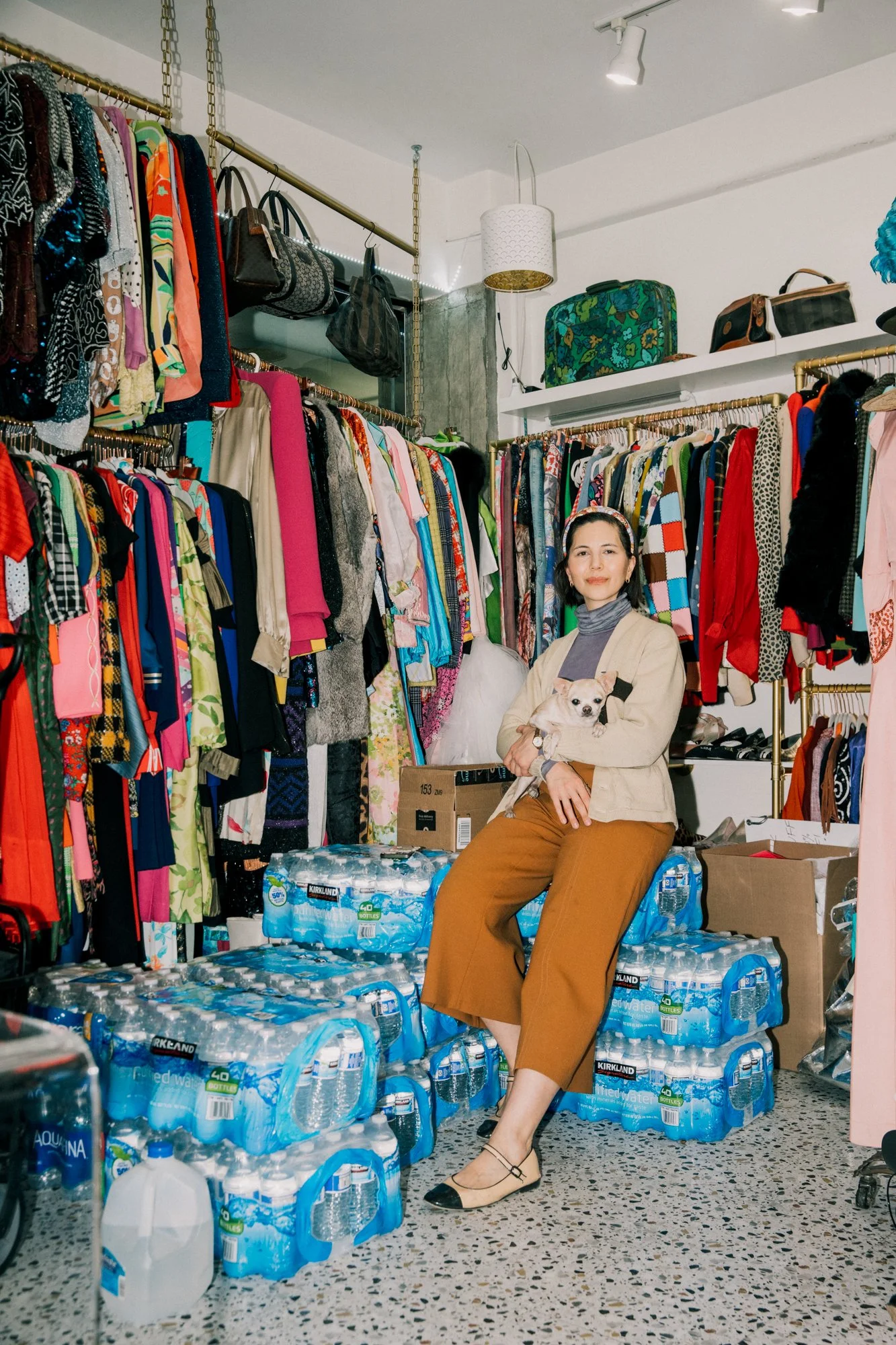 Melynda inside Quirk among clothing racks and donated supplies in January 2025.